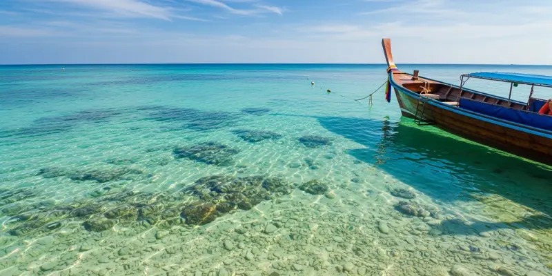 Best Time Visit Thailand Phuket: Weather, Costs & Insider Travel Guide Clear turquoise sea and longtail boat in Phuket peak season